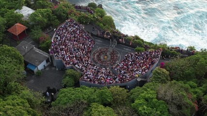Aerial Drone footage of Ulluwatu Temple and audience watching Kecak Dance during sunset