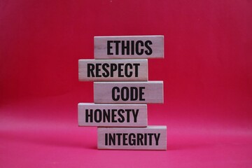 Stacked Wooden Blocks Highlighting Ethics, respect, code, Honesty, and integrity on red Background