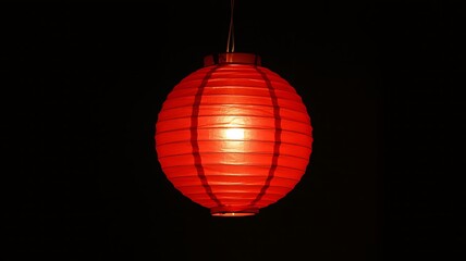 Fototapeta premium Glowing red lantern casts warm light in darkness, perfect for Lunar New Year celebrations
