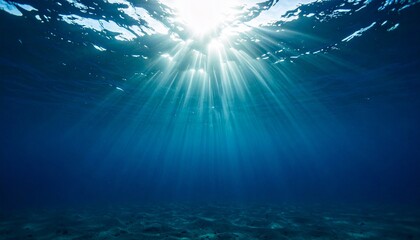 Fototapeta premium Underwater scene with sunlight piercing through the ocean surface, casting radiant beams across clear blue water