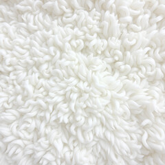 Close-up of a soft, white sherpa fabric with swirling patterns, perfect for backgrounds, textures, and cozy, comfortable designs. The plush material offers warmth and invites relaxation.