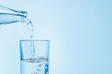 Crystal clear water being poured into a transparent glass, creating refreshing ripples and bubbles