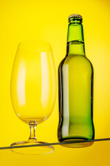 A cold beer bottle standing on a glass table