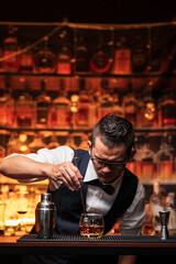 Bartender is pouring whiskey into a glass in a restaurant