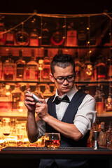 Bartender is pouring whiskey into a glass in a restaurant