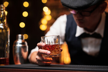 Bartender is pouring whiskey into a glass in a restaurant