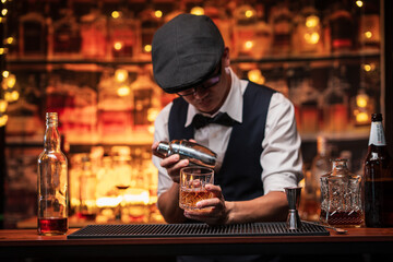 Bartender is pouring whiskey into a glass in a restaurant