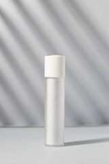 Elegant white cosmetic bottle in soft natural light. A clean, minimalist aesthetic perfect for representing premium skincare, facial serums, and luxury beauty packaging.