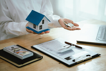 Real estate agents present home designs and discuss documents that reflect real estate investing, property purchases, mortgage planning, home loans, financial advice, and safe housing decisions.