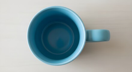 A top-down view of an empty, light blue ceramic mug with a handle on the right side.