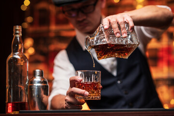Bartender is pouring whiskey into a glass in a restaurant