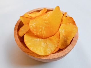 potato chips on a wooden table. cassava chips on white