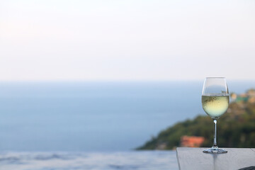glass of cold white wine on the summer seashore by the water, relaxing by the water, a gentle background of soft color
