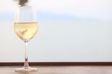 glass of cold white wine on the summer seashore by the water, relaxing by the water, a gentle background of soft color