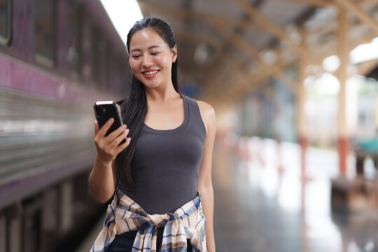 Young woman engaging with smartphone at train station