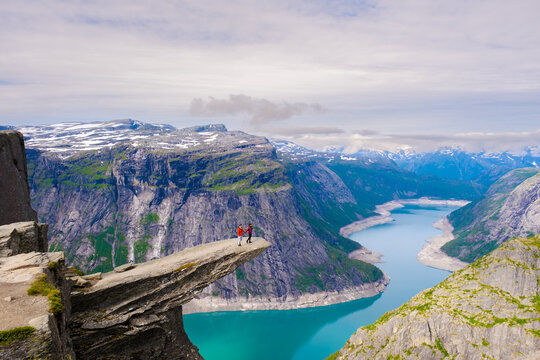 Breathtaking views from the cliff at Preikestolen Norway with adventurous hikers exploring