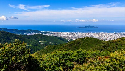 Breathtaking panoramic view of Japanese city and coastline from lush mountain range