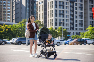Mother pushing baby stroller in outdoor
