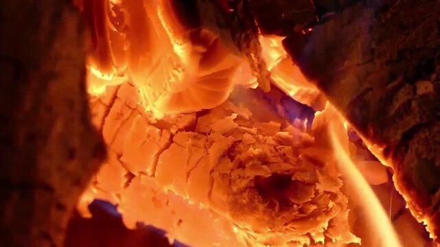 Home fireplace with red flame and firewood. 4K video relaxing endless footage