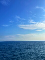 Obraz premium Beautiful view of the open sea beach during the day. Sea ​​view with clear sky and fluffy white clouds. Feeling calm, cool, relaxing. The concept of peaceful nature suitable for tourism. 