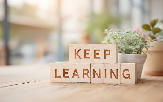 Wooden letter blocks spelling "Keep Learning" on a table with soft daylight