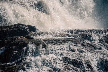 streams of clear waterfall water and stone banks of a mountain river