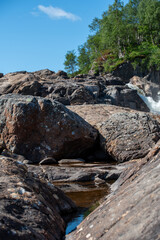 streams of clear waterfall water and stone banks of a mountain river