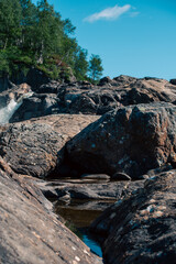 streams of clear waterfall water and stone banks of a mountain river