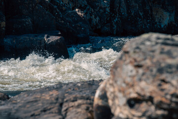 streams of clear waterfall water and stone banks of a mountain river