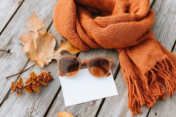 Vintage scarf and sunglasses create a warm autumn moodboard on wooden surface