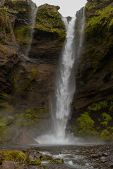 Obraz premium Tall Waterfall Cascading Down Moss Covered Cliff in Iceland
