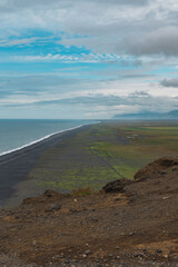 Black Sand Beach and Green Fields Along Iceland's Southern Coastline