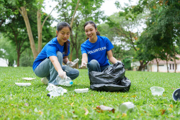 Volunteers collecting trash in park wearing blue shirts