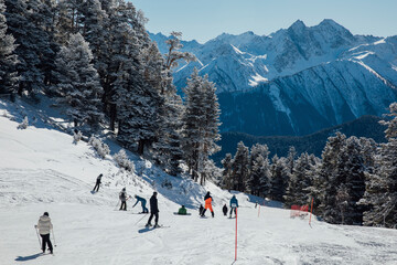 Snowboarders and skiers ski in the resort on the slopes