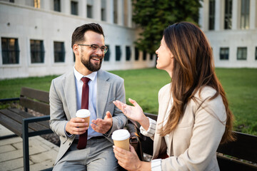 Business colleagues enjoying coffee break and conversation outdoors