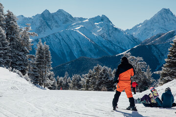Snowboarders and skiers ski in the resort on the slopes