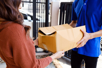 Customer receiving a damaged cardboard box from a delivery man outdoors. Concept of poor shipping...