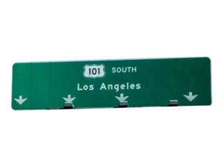 Road to Los Angeles: A sign post indicates the direction to Los Angeles, a bustling metropolis, along a highway, a symbol of journey and transit.