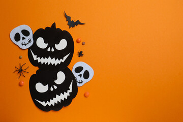 Black pumpkins, skull, bats, spiders and confetti. Halloween festive background . Top view, space for text