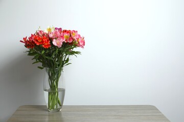 Colorful alstroemeria flowers in glass vase on the table