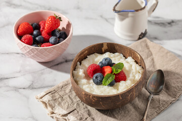 Rice milk porridge in with berries in a bowl on the table. Healthy breakfast