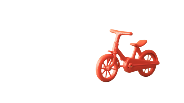Close up of a red toy bicycle against a plain black background on transparent background