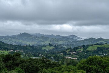 Naklejka premium Rolling hills blanketed by overcast sky