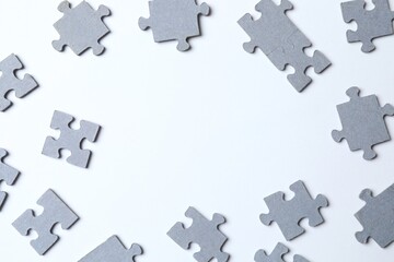 Top view of scattered puzzle pieces on white background 