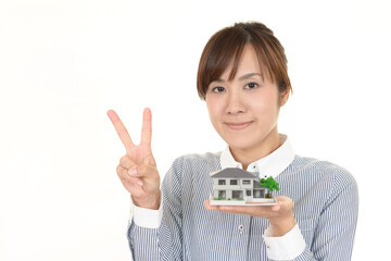 家の模型を持つ女性