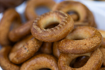 Freshly baked mini bagels on a dark background. Top view. Pretzels in the form of a ring close-up. Small bread circle biscuit. Bowls with different types of bagels.