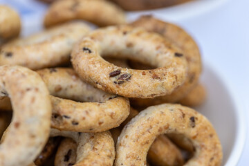 Freshly baked mini bagels on a dark background. Top view. Pretzels in the form of a ring close-up. Small bread circle biscuit. Bowls with different types of bagels.