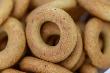 Freshly baked mini bagels on a dark background. Top view. Pretzels in the form of a ring close-up. Small bread circle biscuit. Bowls with different types of bagels.