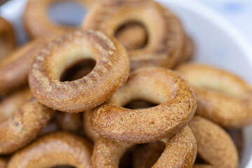Freshly baked mini bagels on a dark background. Top view. Pretzels in the form of a ring close-up. Small bread circle biscuit. Bowls with different types of bagels.