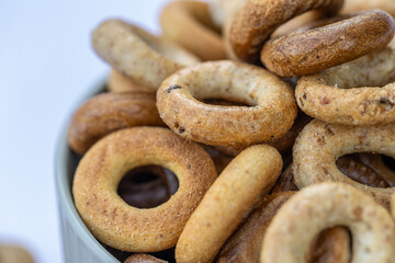 Freshly baked mini bagels on a dark background. Top view. Pretzels in the form of a ring close-up. Small bread circle biscuit. Bowls with different types of bagels.